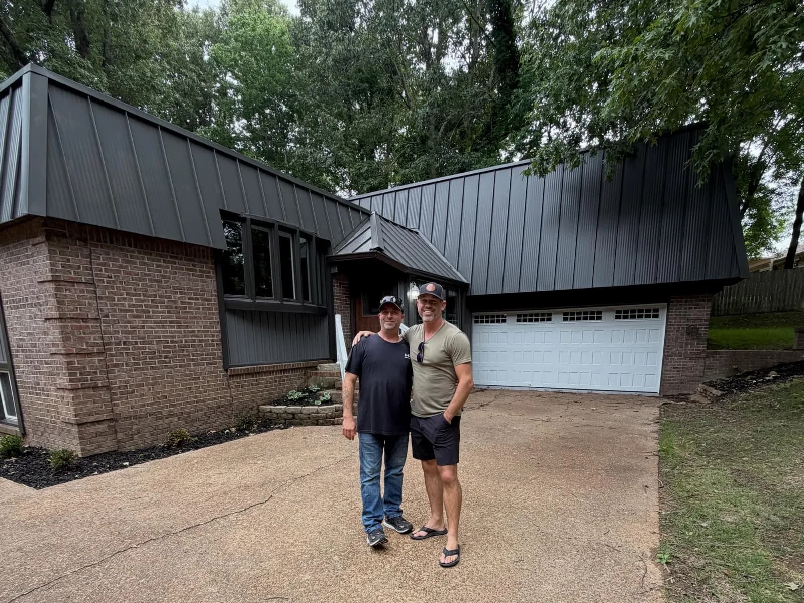Casey Roloff and Eddie Hembd in the driveway of one of their renovated flips